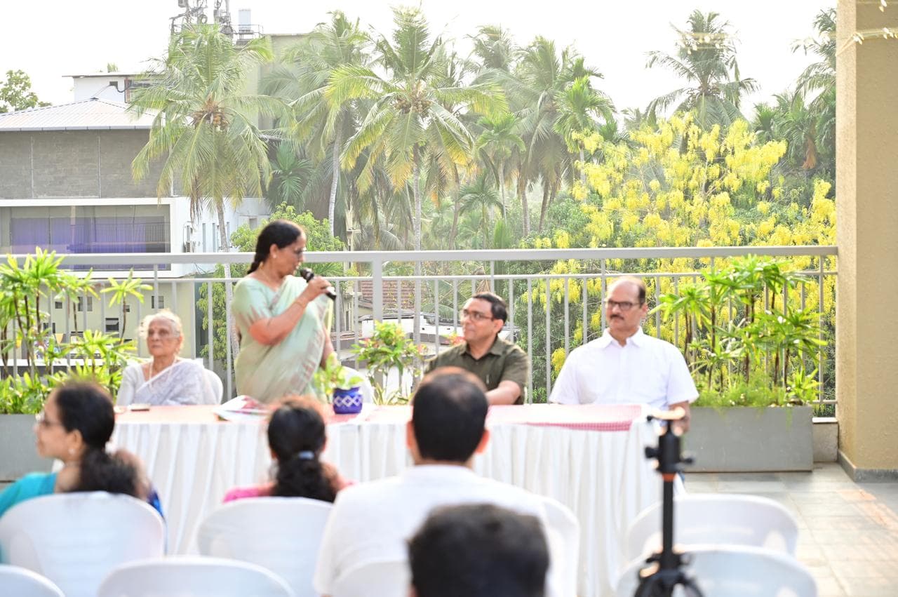 Community member speaking on stage with seated guests nearby