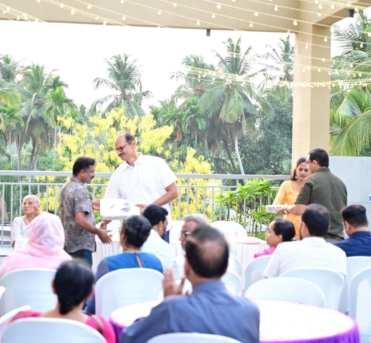 Prize distribution under string lights during the evening gathering