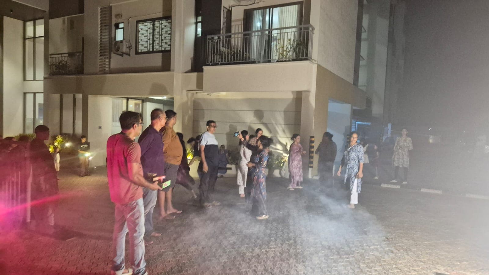 Community members watching fireworks in the apartment courtyard