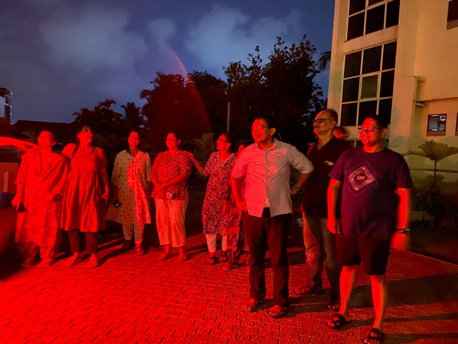 Residents standing together under red light during the celebration